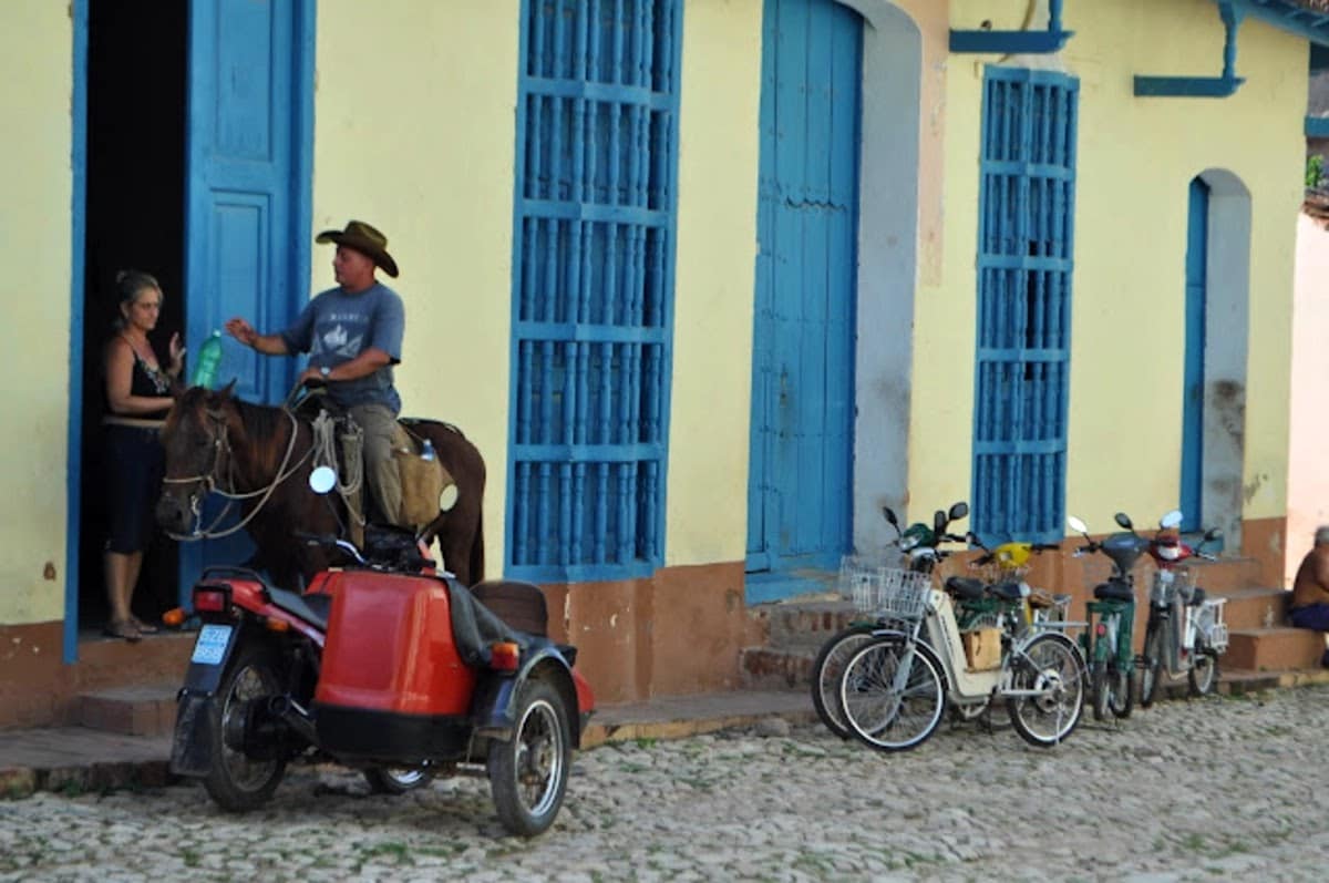 Sidecar y vaquero cubano Un vaquero al lado de un sidecar en Trinidad