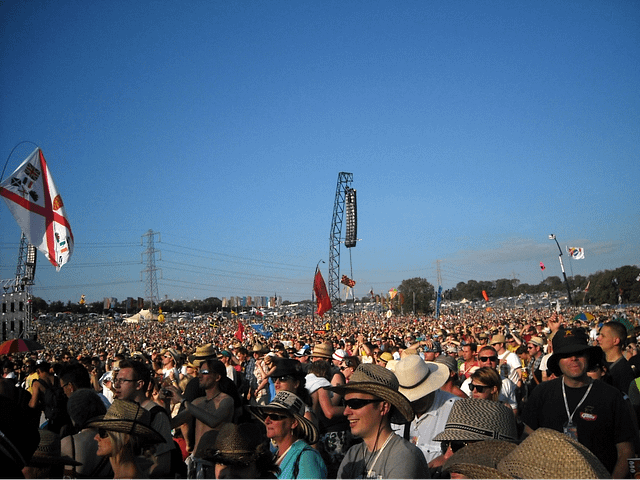 Marea de gente en Glastonbury: vista multitudinaria del festival Vista panorámica de una multitud inmensa en Glastonbury Festival, con miles de asistentes hasta donde alcanza la vista